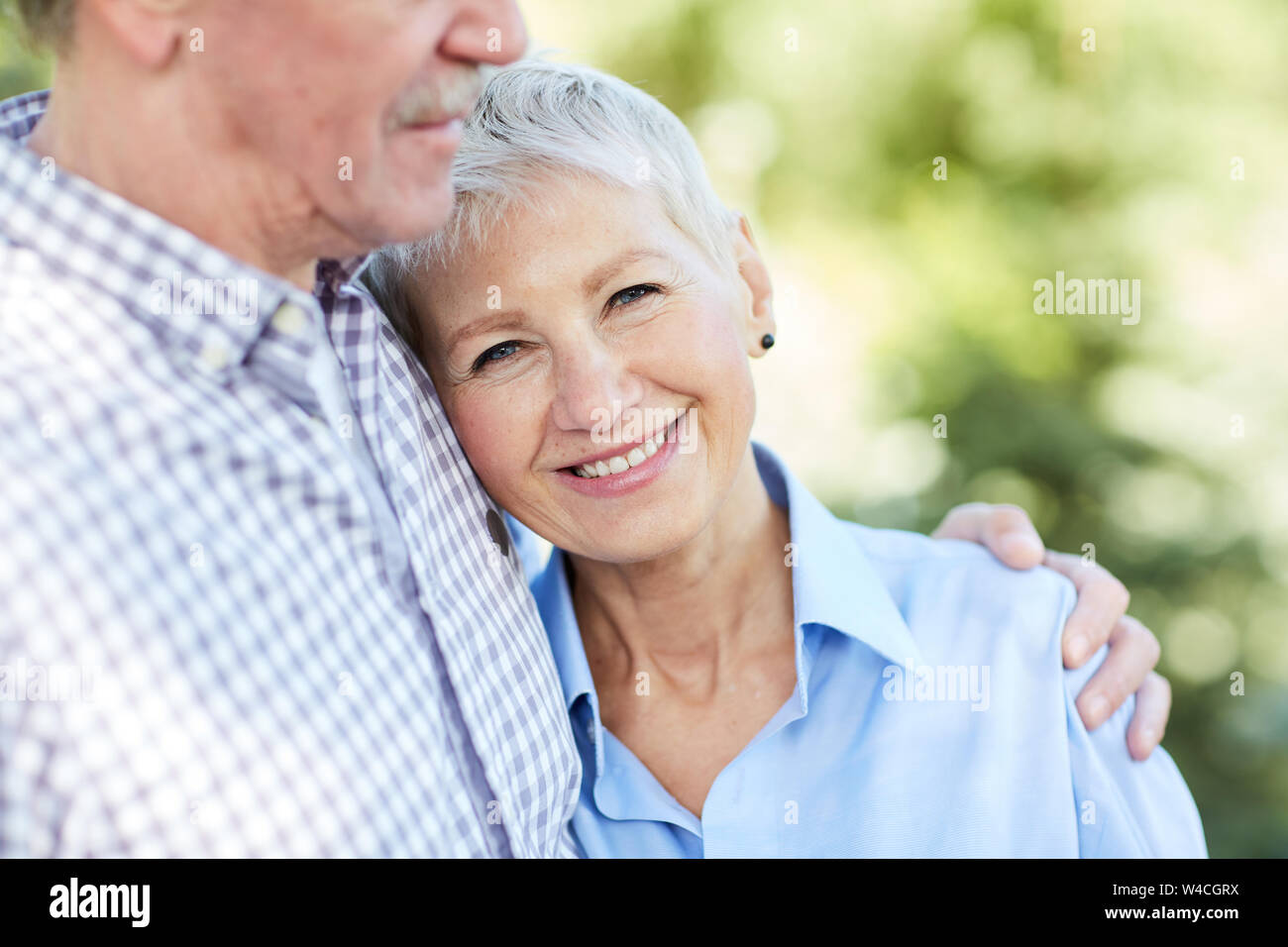 La mi-section portrait de senior couple embracing, focus sur elegant woman smiling at camera, copy space Banque D'Images