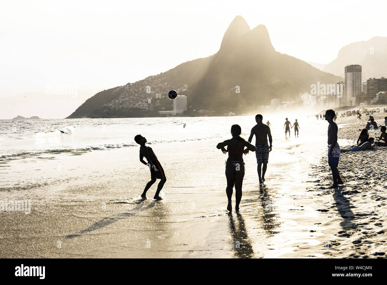 RIO DE JANEIRO, Brésil - 24 février 2015 : un groupe de Brésiliens jouant sur le rivage de la plage d'Ipanema, avec la célèbre montagne Dois Irmãos derrière eux Banque D'Images