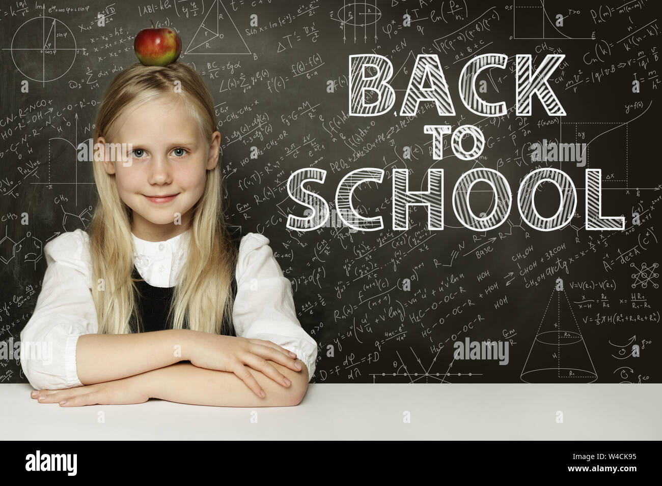 School girl Smiling avec Apple sur la tête. Retour à l'école contexte concept Banque D'Images