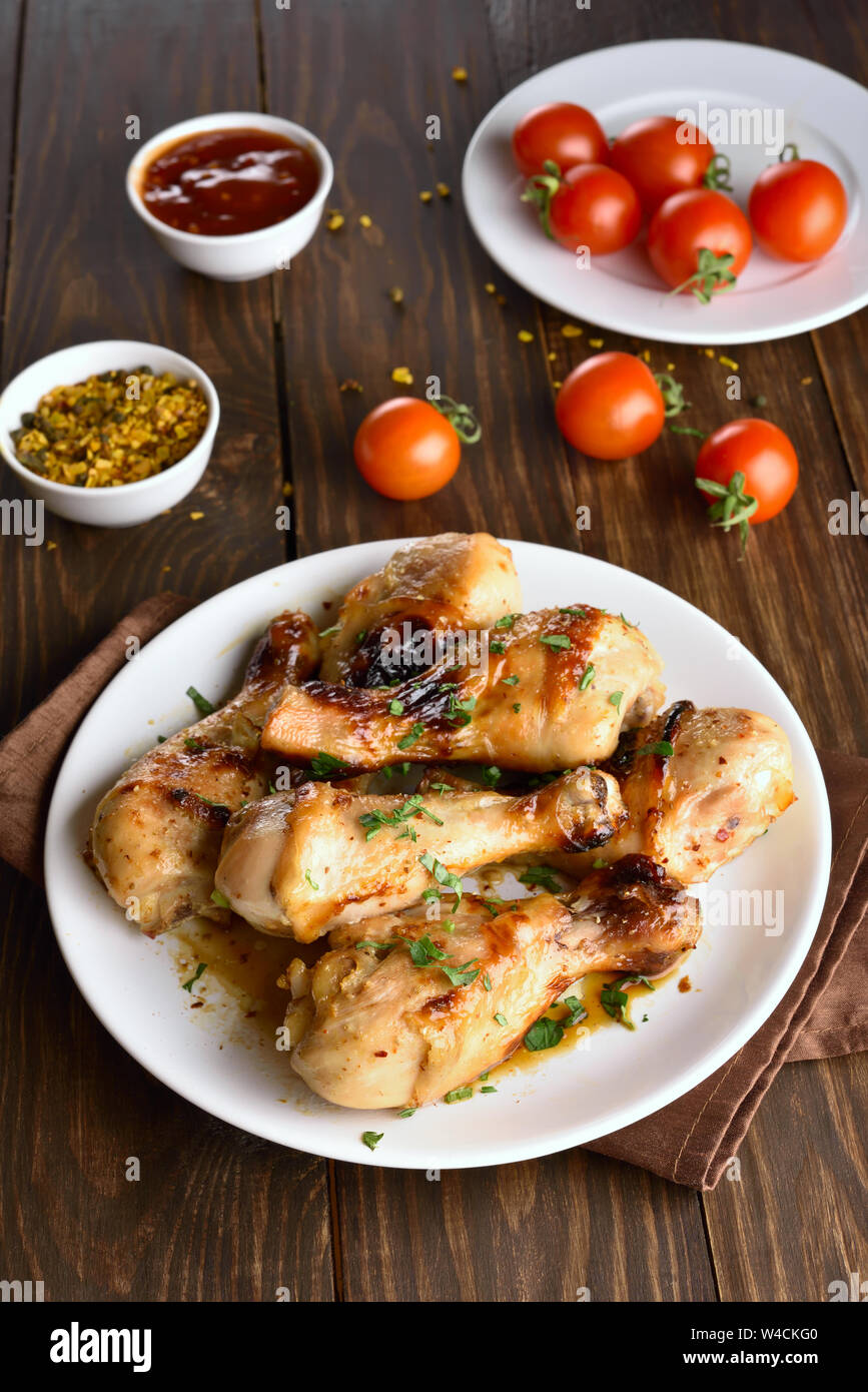 Pilons de poulet au four sur plaque blanche Banque D'Images