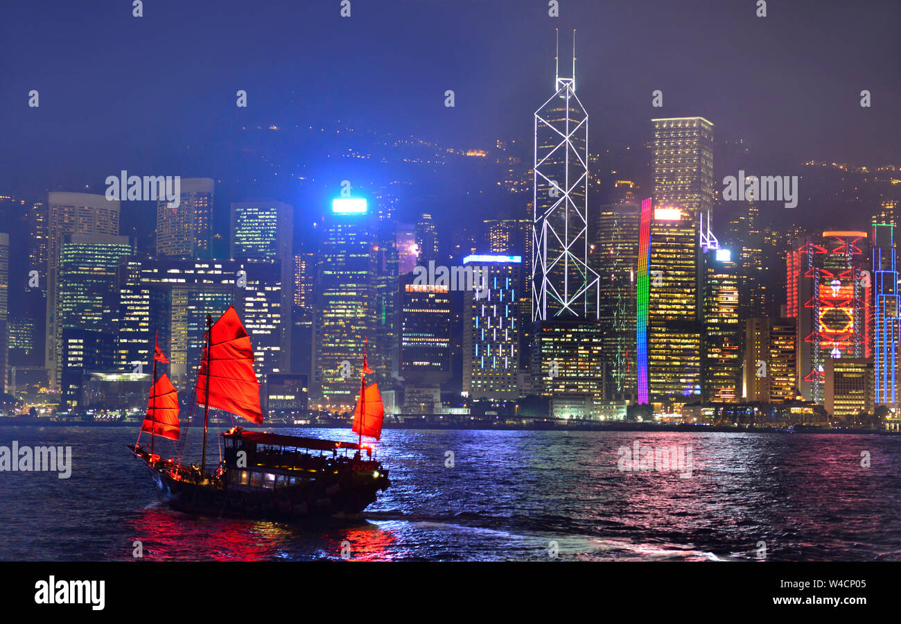 Hong Kong skyline at night avec croisière voilier traditionnel (Dukling) au port de Victoria. Banque D'Images