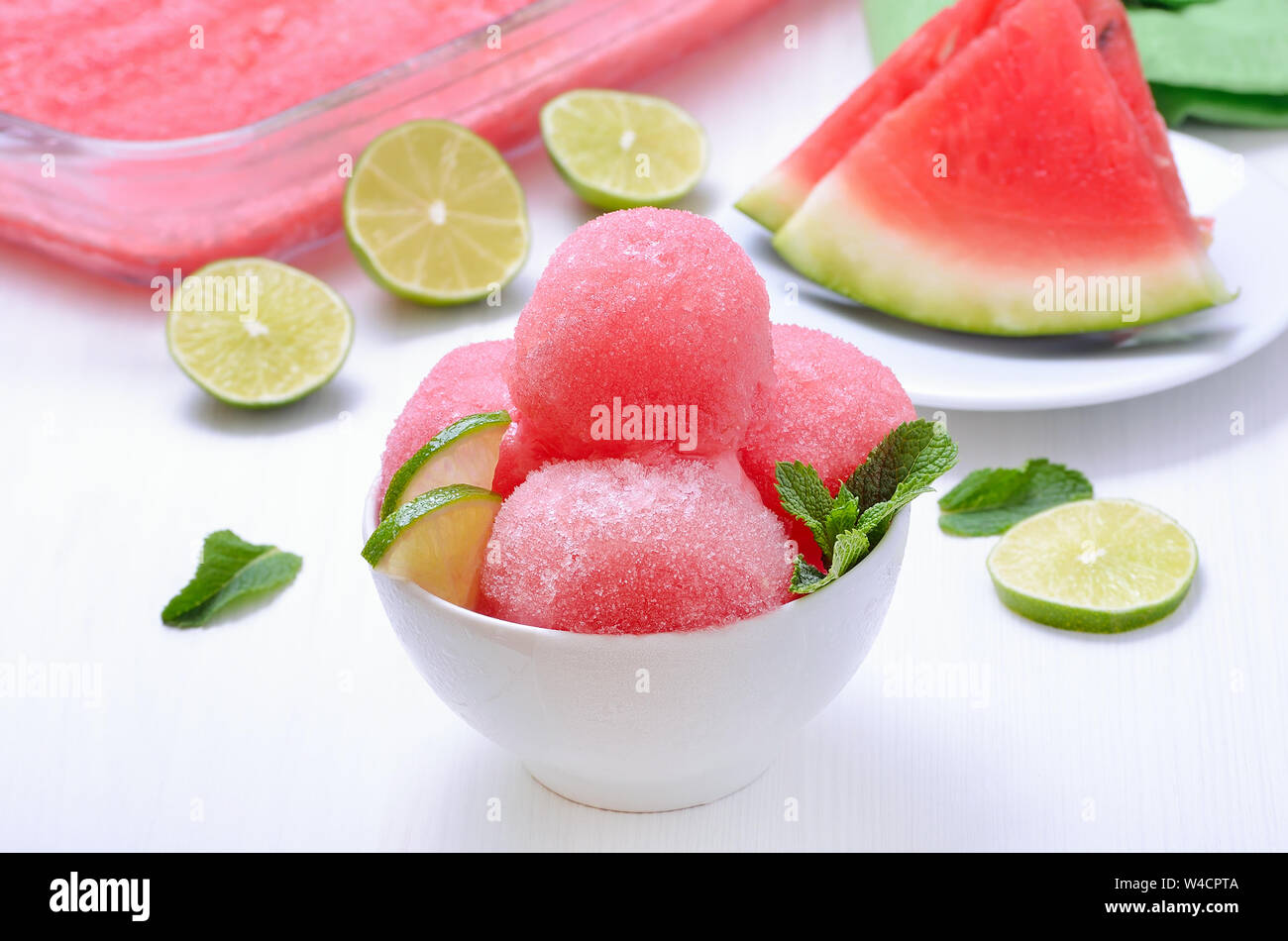 Boule de sorbet pastèque décorée de tranches de lime et de menthe Banque D'Images