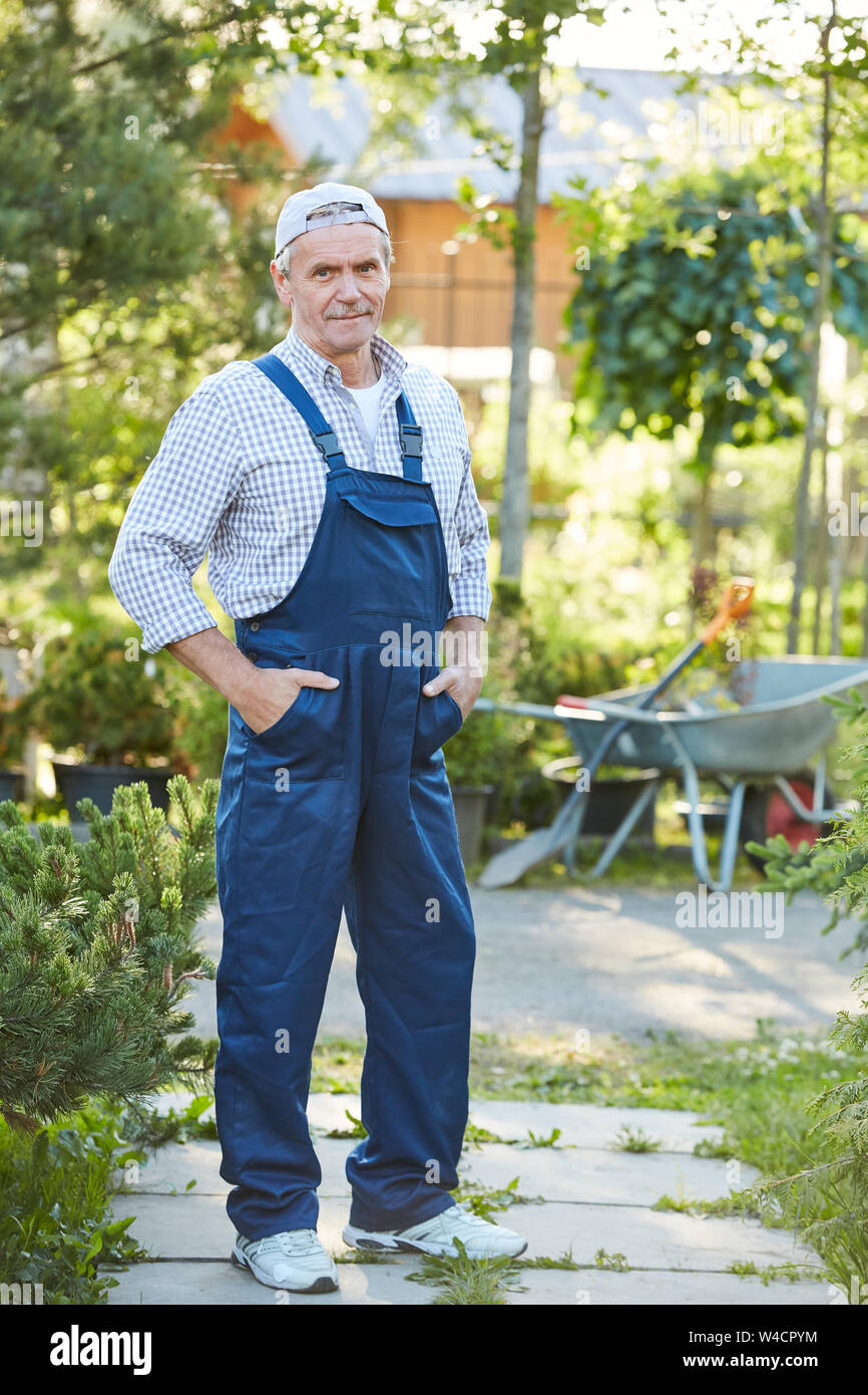 Portrait of senior couple smiling at camera et posant tout en travaillant à la ferme, copy space Banque D'Images