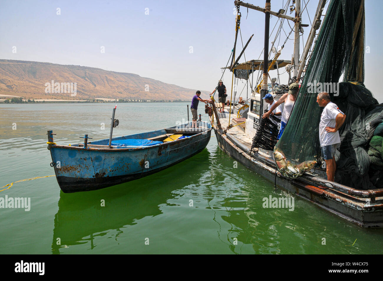 Bateau de pêche et de canot en arrondissant les poissons dans un filet de la mer de Galilée, Israël Banque D'Images