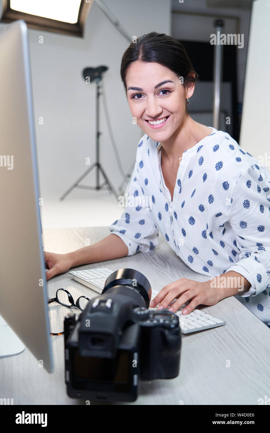 Portrait de femme photographe en studio l'examen des images de la séance photo sur l'ordinateur Banque D'Images