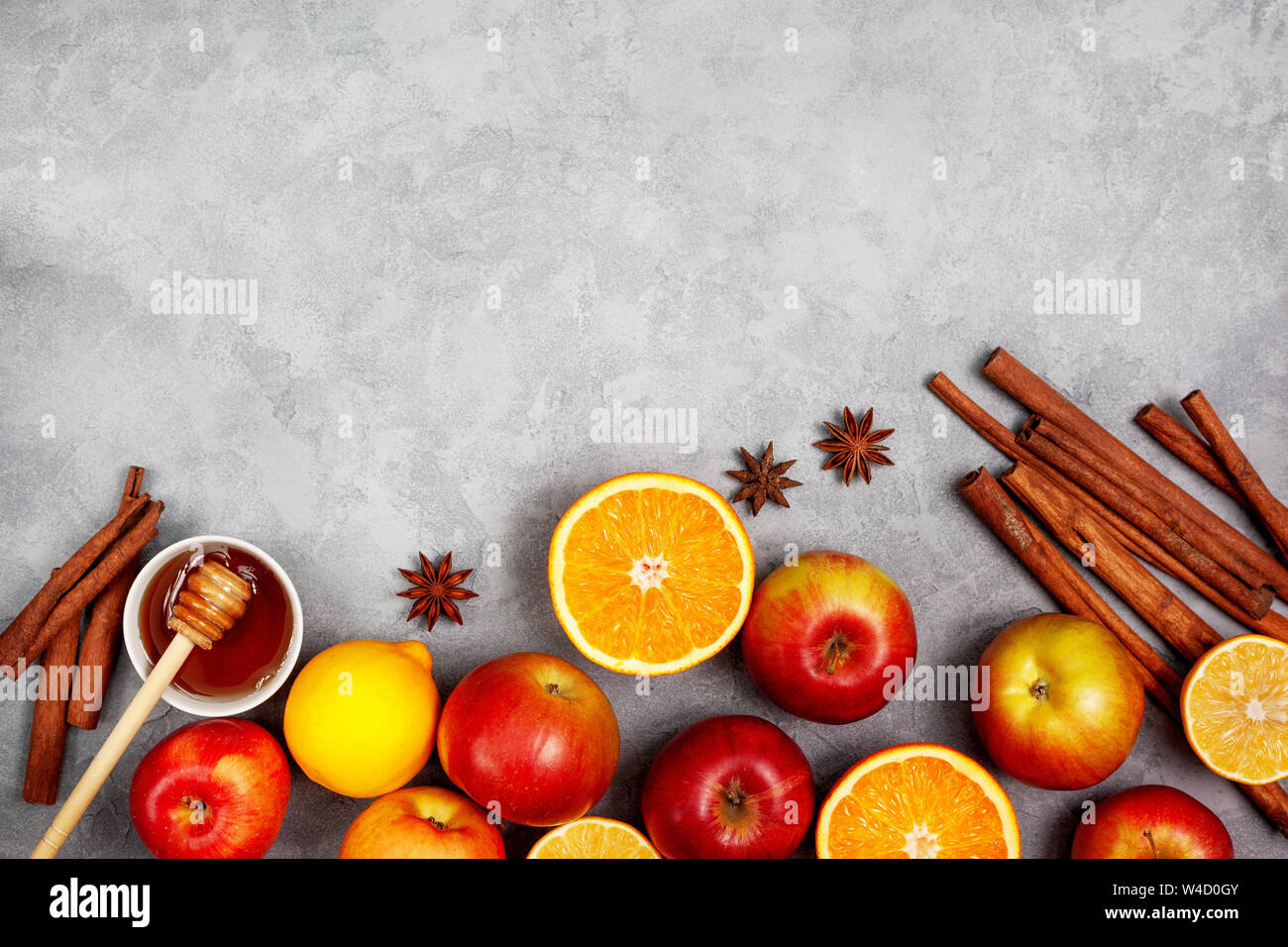Fond de noël. Ingrédients pour boissons d'hiver (vin chaud, punch, thé) : pommes, oranges, citrons et d'épices sur un fond de béton gris. voir fr Banque D'Images