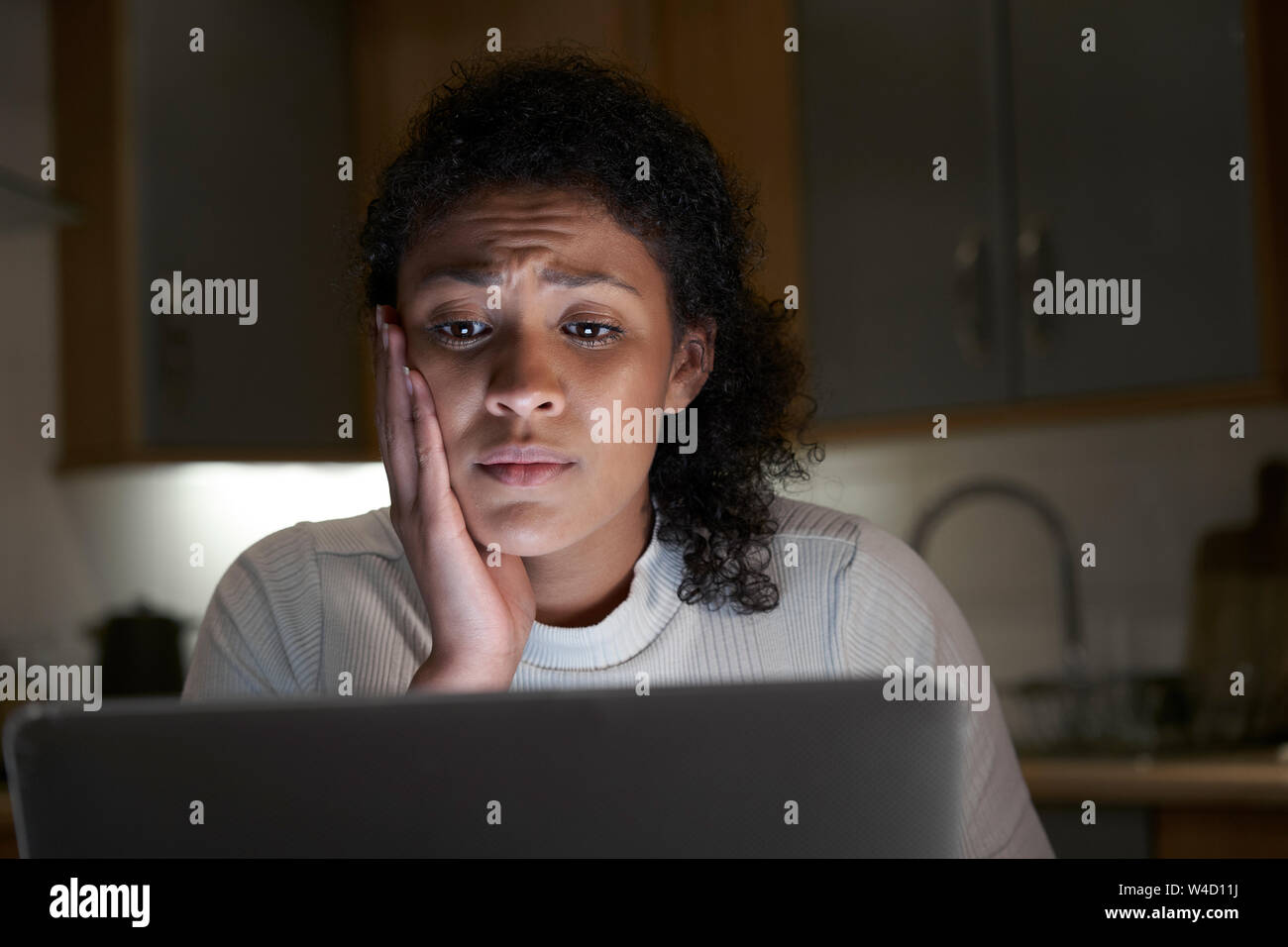 Femme malheureuse à la maison avec l'ordinateur de l'intimidation en ligne sur les médias sociaux Banque D'Images
