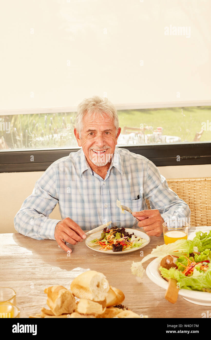 Les cadres supérieurs en tant que végétarien à dîner sain avec une salade fraîche à la table Banque D'Images