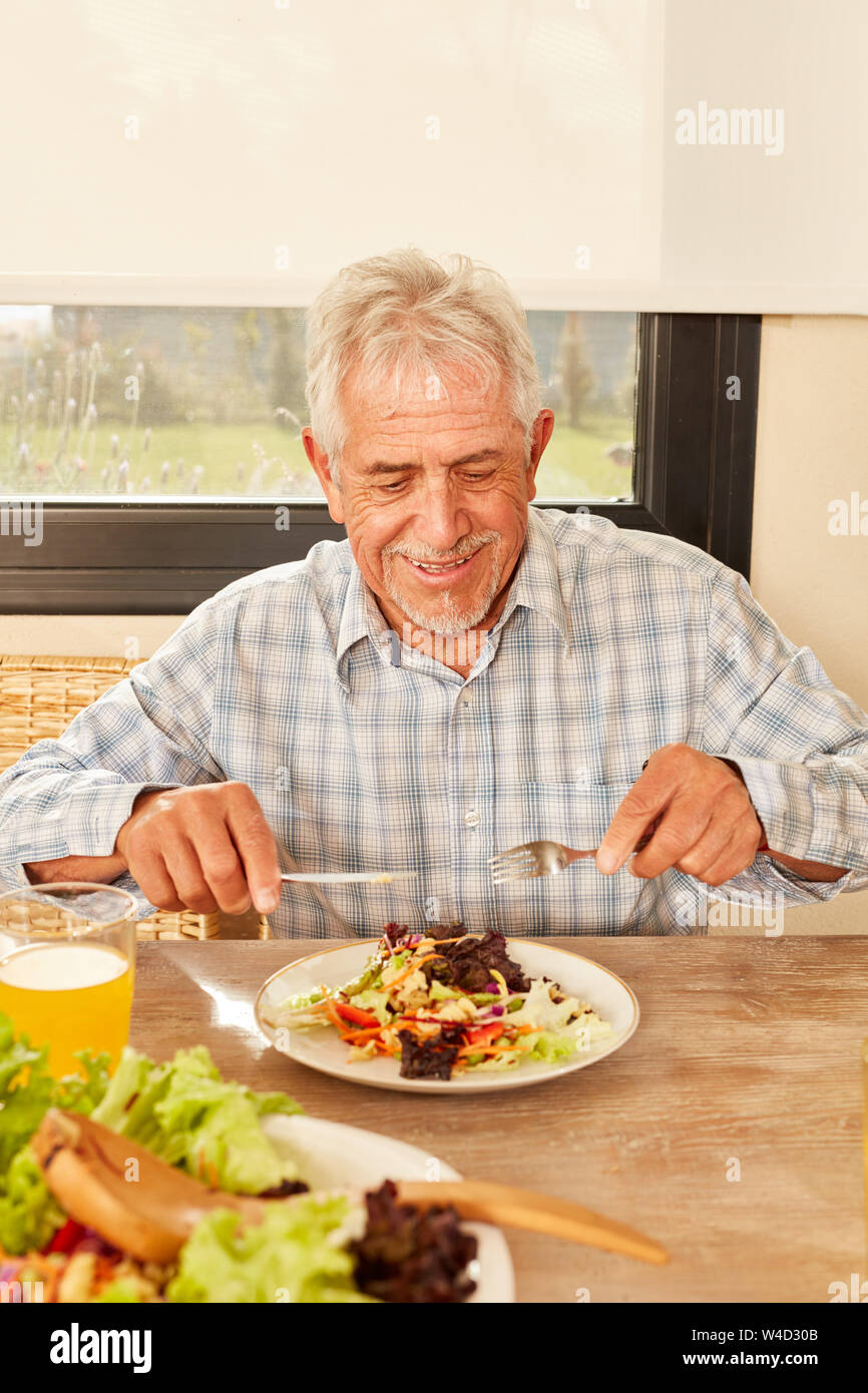 Man en tant que végétarien en mangeant de la salade pour le déjeuner ou le dîner Banque D'Images