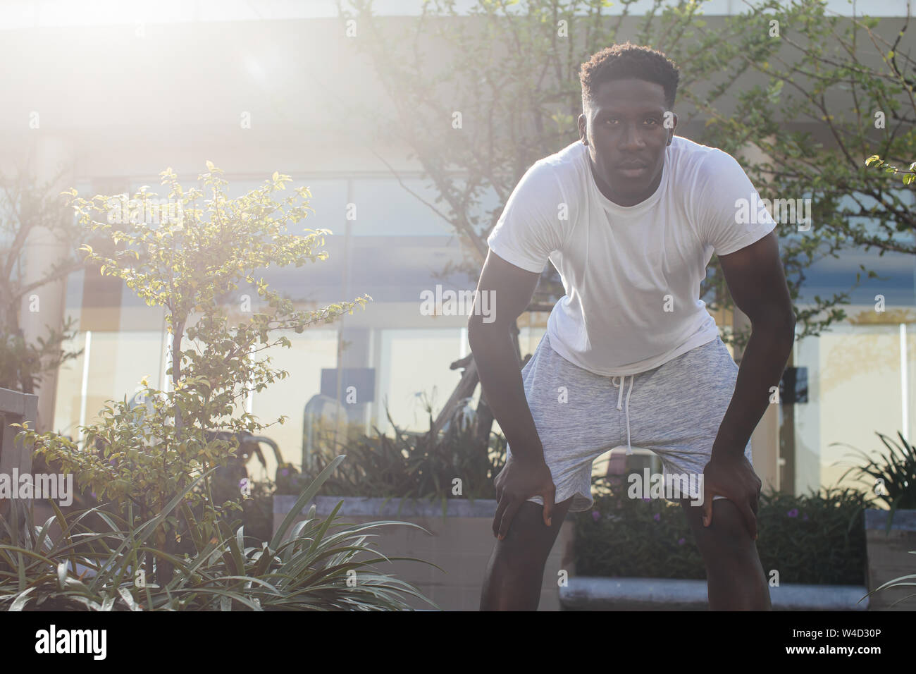 Portrait of African American man prendre du repos pendant le jogging. Jeune mâle personne digne de faire de l'exercice et faire une pause dans le parc de la ville Banque D'Images