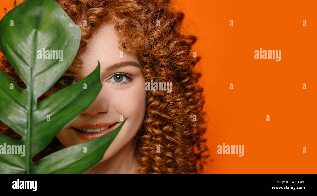 Femme avec les yeux verts et les cheveux bouclés holding Green leaf près de  visage Photo Stock - Alamy