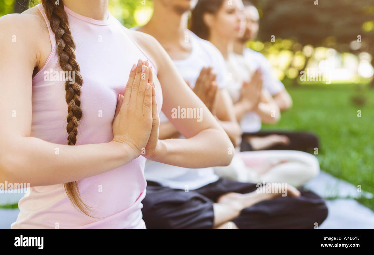 Close up de gens faisant des geste namaste yoga à l'extérieur de la classe Banque D'Images