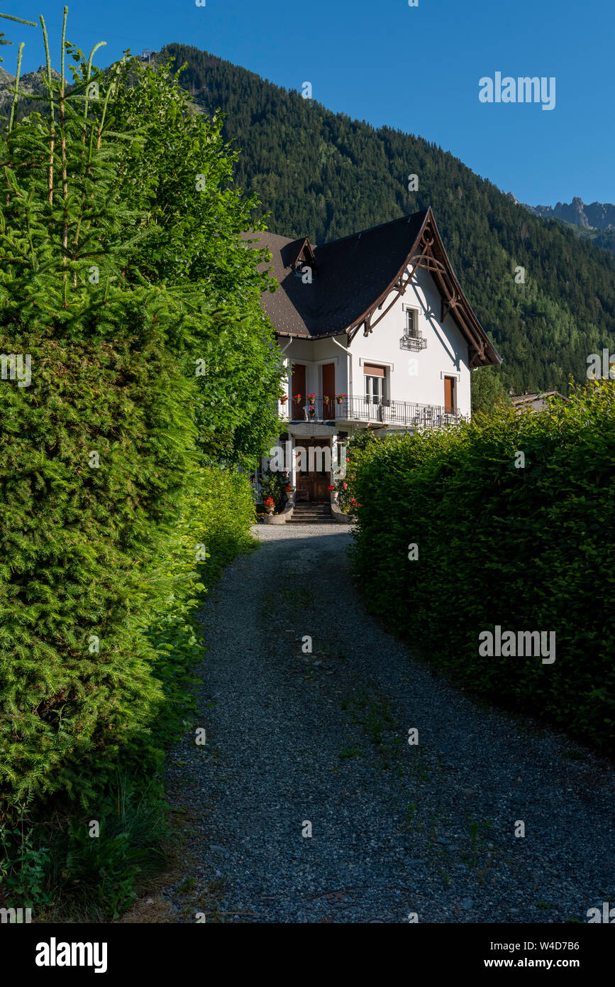 Maison au coeur de la montagne près de Chamonix Mont Blanc, France sur une journée ensoleillée avec des arbres verts et ciel bleu, Chamonix-Mont-Blanc Rhone-Alpes Fra Banque D'Images