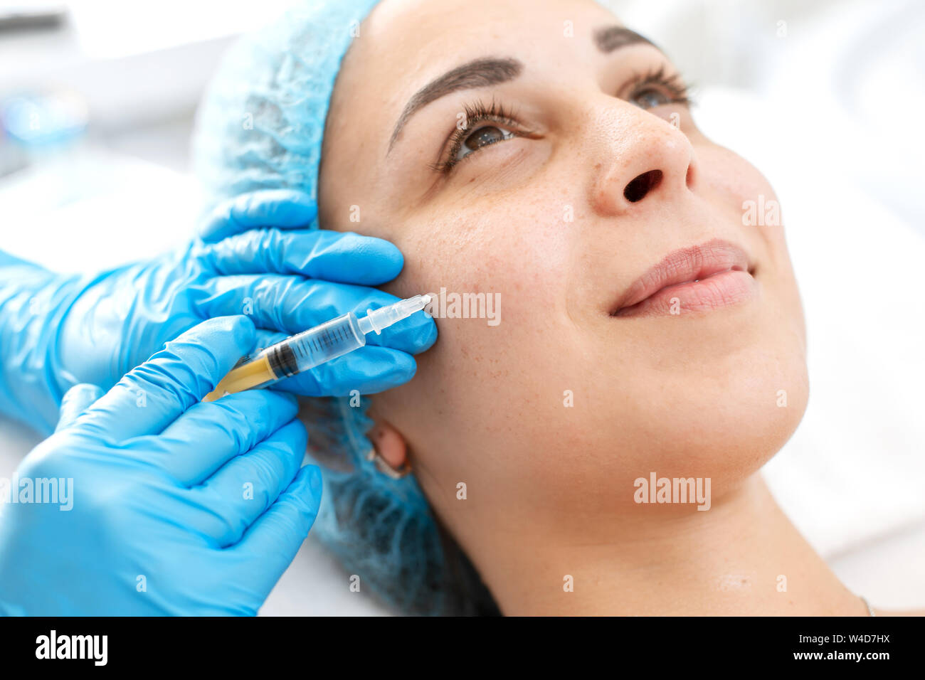 L'esthéticienne professionnelle rend les injections de vitamine de rajeunissement de la peau du visage du patient. Une jeune fille est en cours de traitement de spa Banque D'Images