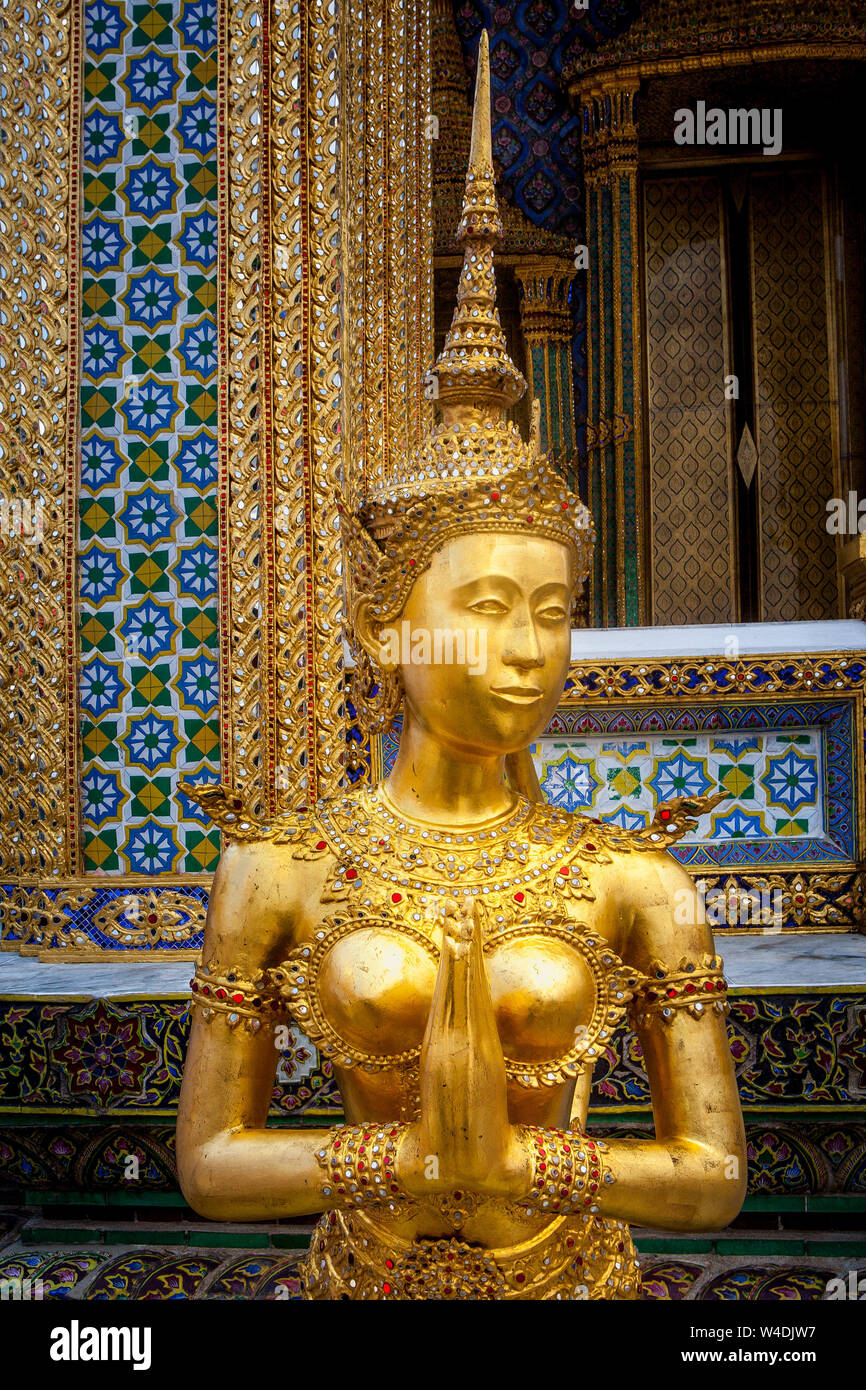 La figure d'or d'un mi-homme mi-oiseau appelé un Kinnara garde le Temple du Bouddha d'émeraude au Grand Palais à Bangkok, Thaïlande. Banque D'Images