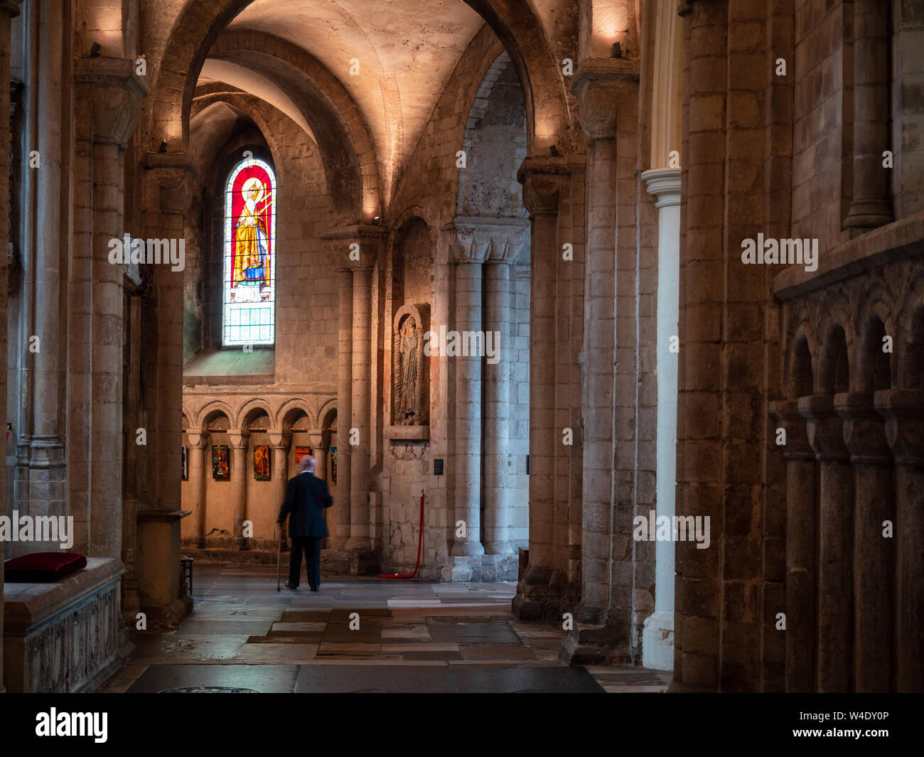 Un vieil homme marche à l'intérieur de la cathédrale de Norwich, Angleterre, Royaume-Uni Banque D'Images