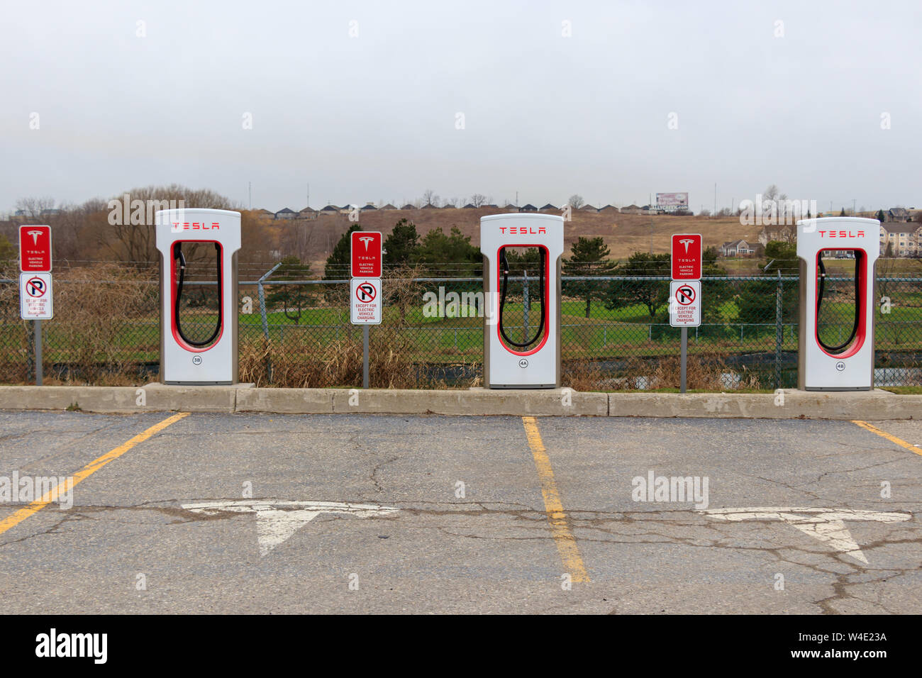 Tesla Supercharger stalles et espace stationné avec marqué 'T' Tesla emblème. Banque D'Images Tesla Supercharger stalles et espace stationné avec marqué 'T' Tesla emblème. Banque D'Images