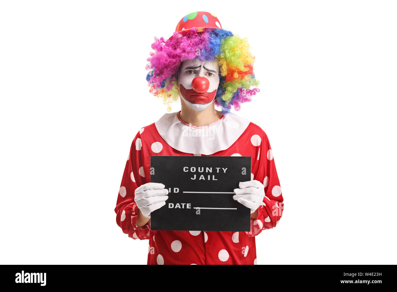 Clown triste posant avec un conseil prison isolé sur fond blanc Banque D'Images