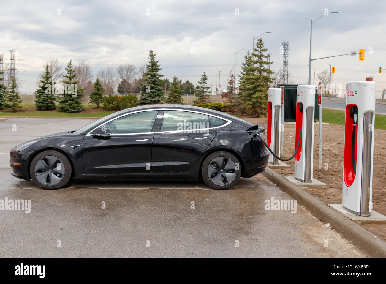 Tesla Model 3 noir branché en charge de Tesla, à Mississauga. Banque D'Images