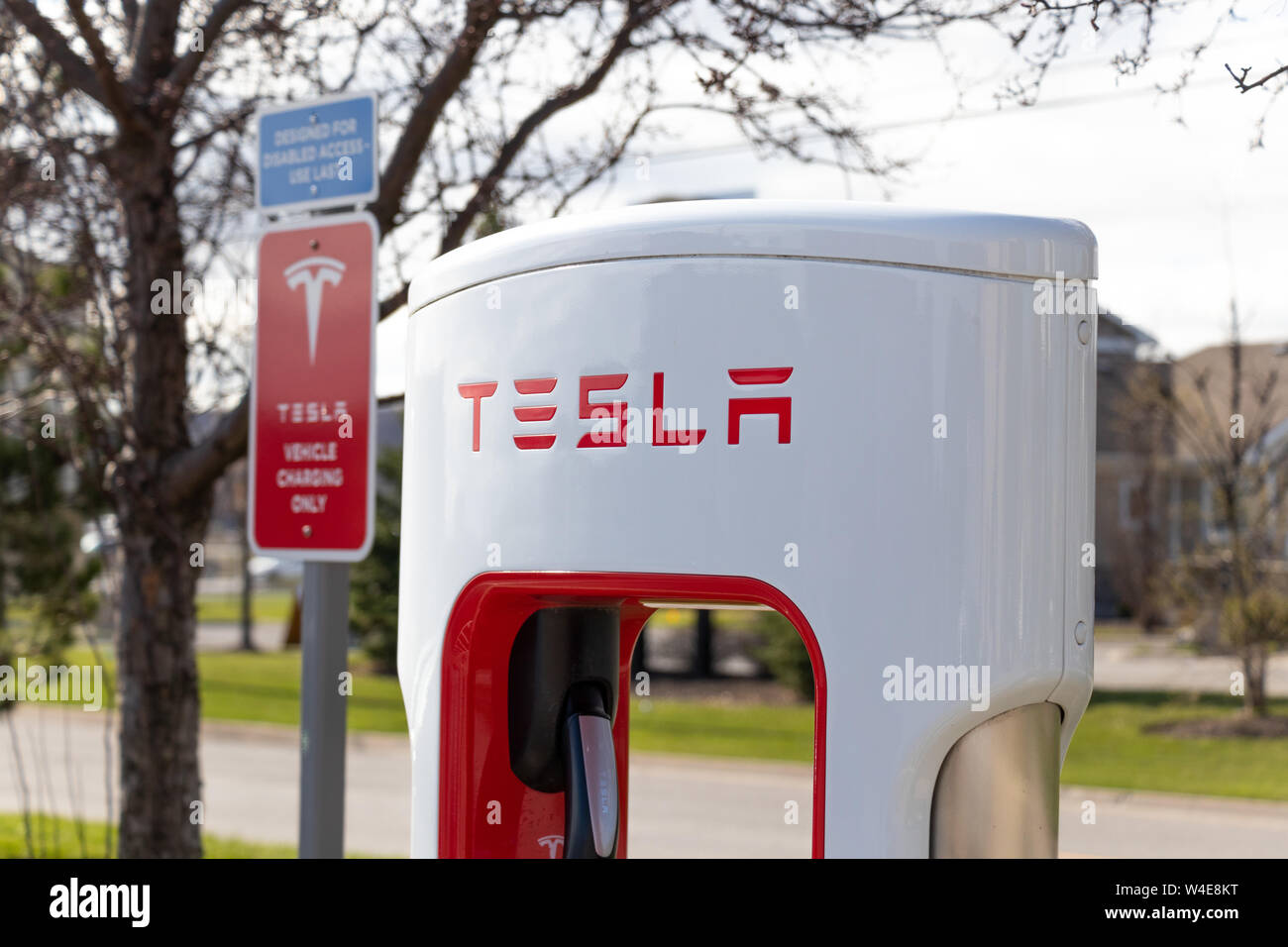 Haut de Tesla avec décrochage compresseur de charge du véhicule Tesla 'uniquement' inscrivez-vous à l'arrière-plan. Banque D'Images Haut de Tesla avec décrochage compresseur de charge du véhicule Tesla 'uniquement' inscrivez-vous à l'arrière-plan. Banque D'Images