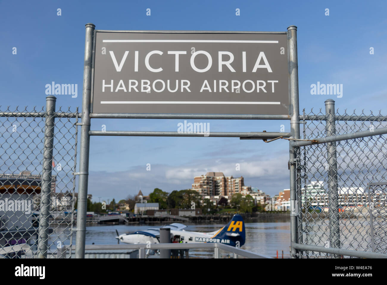 Panneau de l'aéroport Victoria Harbour au-dessus de l'entrée du terminal avec un hydravion Harbour Air vu amarré en dessous. Banque D'Images