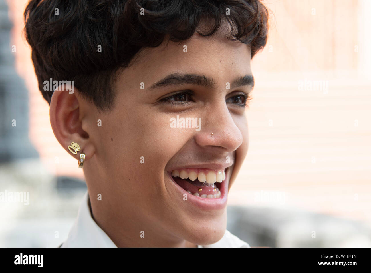 Jeune garçon cubain se moque de ses amis révélant une langue piecing et montrant outre de plusieurs boucles d' Banque D'Images
