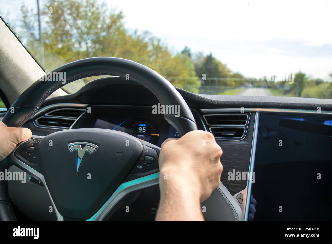 Homme conduisant Tesla Model S. Interior couvert de cuir noir et gris. Banque D'Images