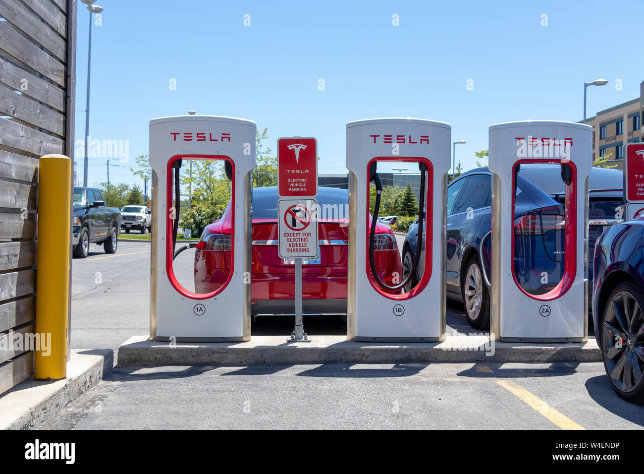 Trois stands de suralimentation Tesla Model S et le modèle X branché à l'arrière. Banque D'Images Trois stands de suralimentation Tesla Model S et le modèle X branché à l'arrière. Banque D'Images
