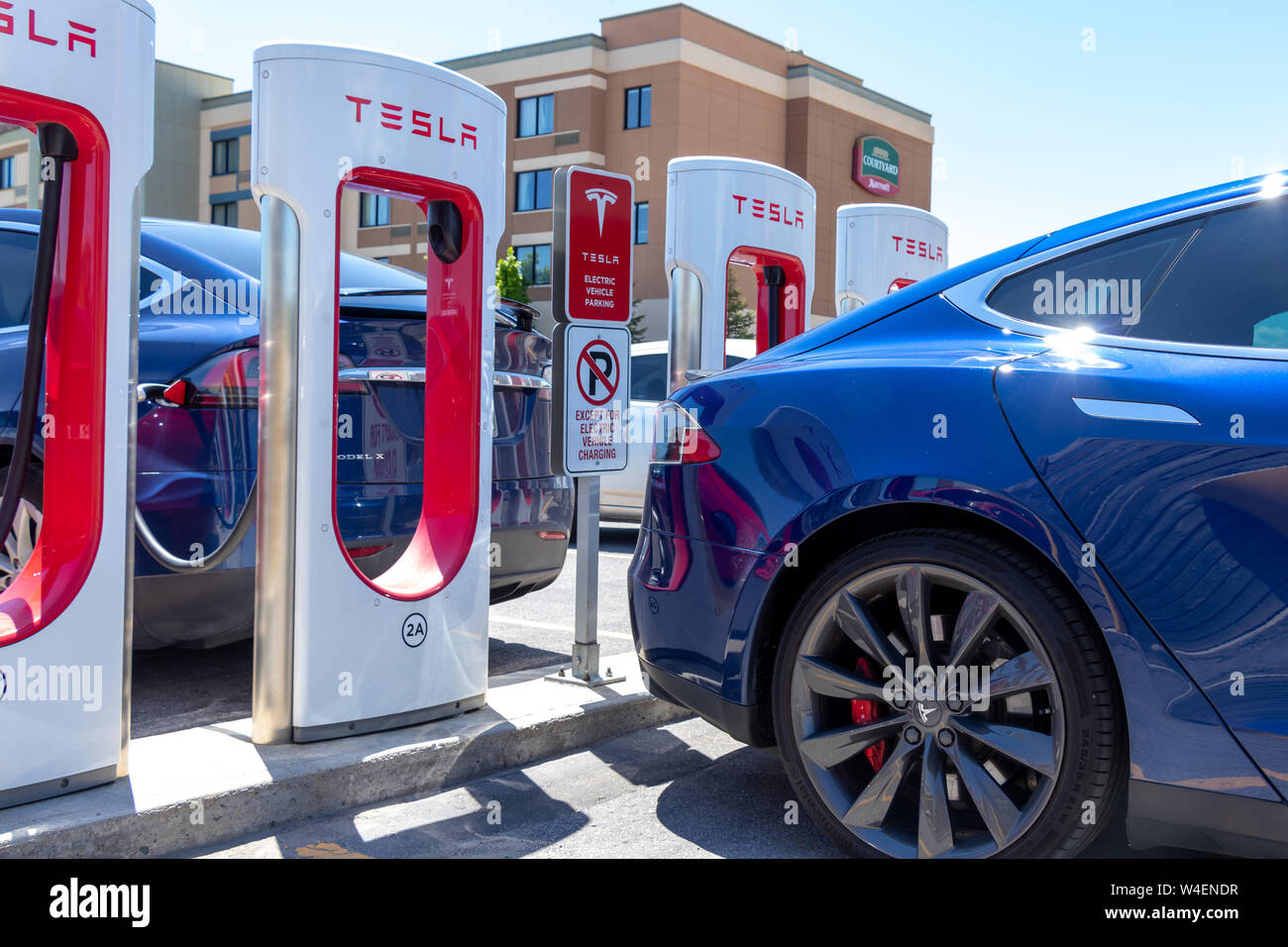 Tesla Model S Bleu et Tesla Model X chez Tesla Supercharger sur une journée ensoleillée. Banque D'Images Tesla Model S Bleu et Tesla Model X chez Tesla Supercharger sur une journée ensoleillée. Banque D'Images