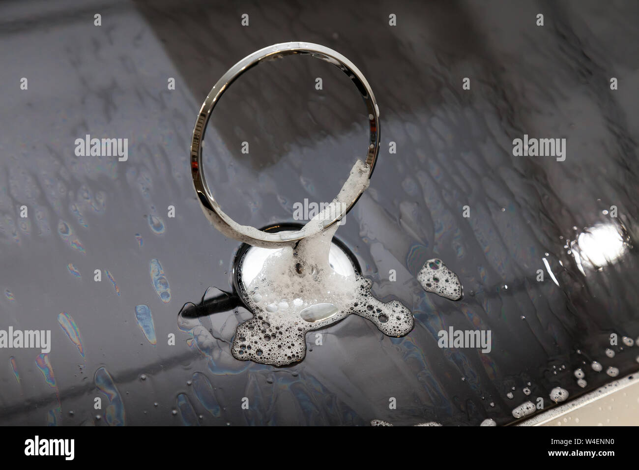 Gros plan sur l'emblème d'un ca sur le capot d'une voiture noire pendant le lavage et le nettoyage dans le détail atelier avec de l'eau et du savon en mousse Banque D'Images