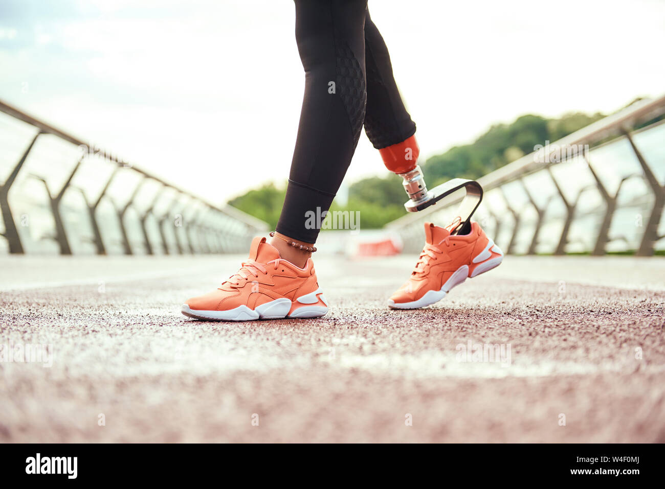 Portrait de femme handicapée avec prothèse de jambe debout sur le pont le matin. Mobilité sport concept. La motivation. Mode de vie sain Banque D'Images