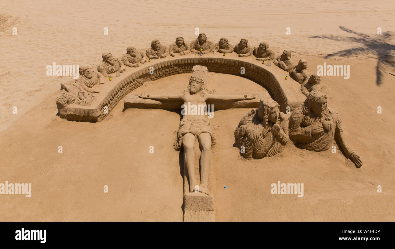 Sculpture de sable d'une scène religieuse avec le Christ sur une croix sur la plage de sable Banque D'Images