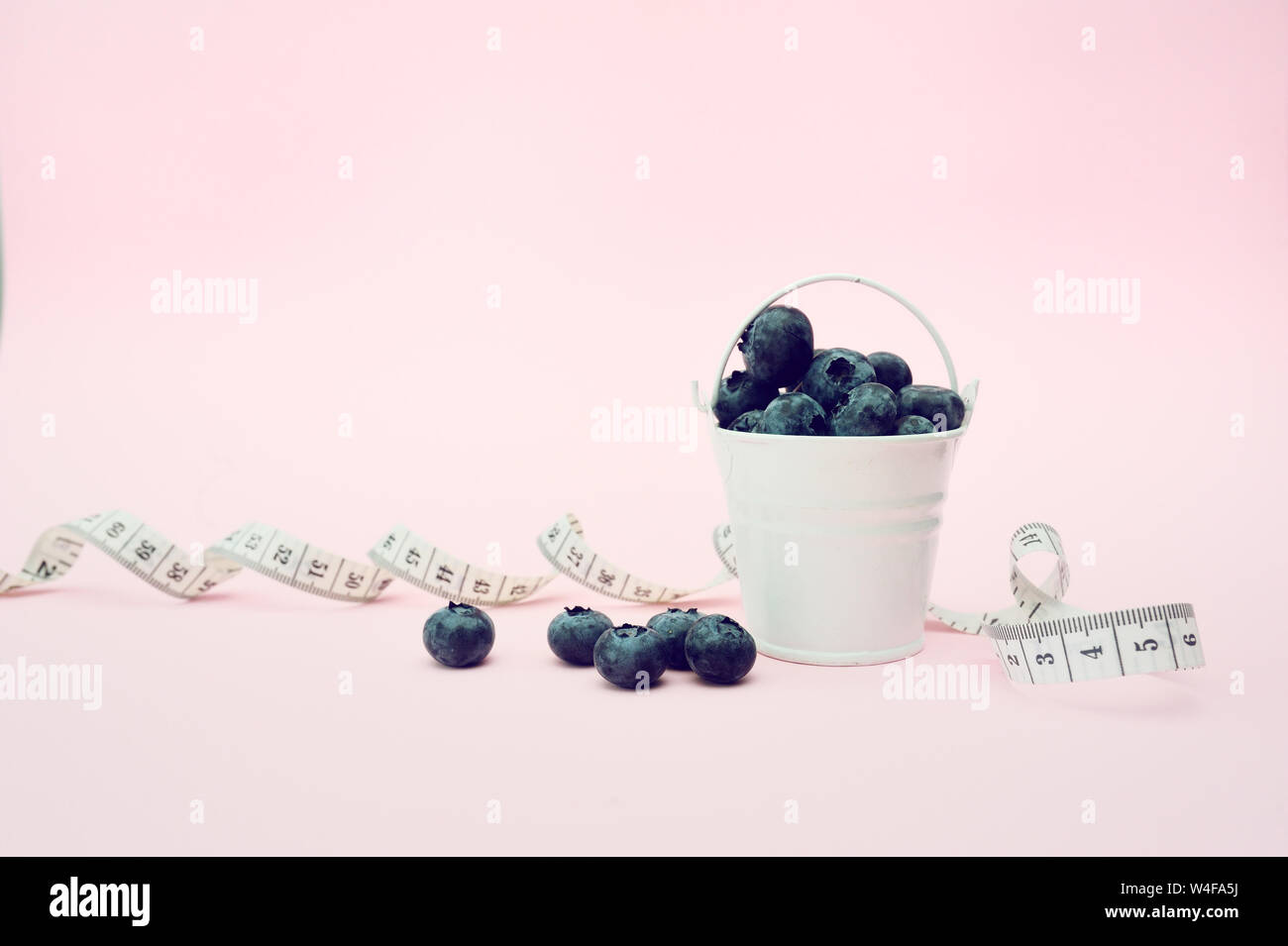 Les bleuets de l'été dans le godet sur fond rose. Petits fruits pour la conception. Close up Vue de dessus ou de mise à plat avec place pour votre texte. Régime alimentaire médical Concept Banque D'Images