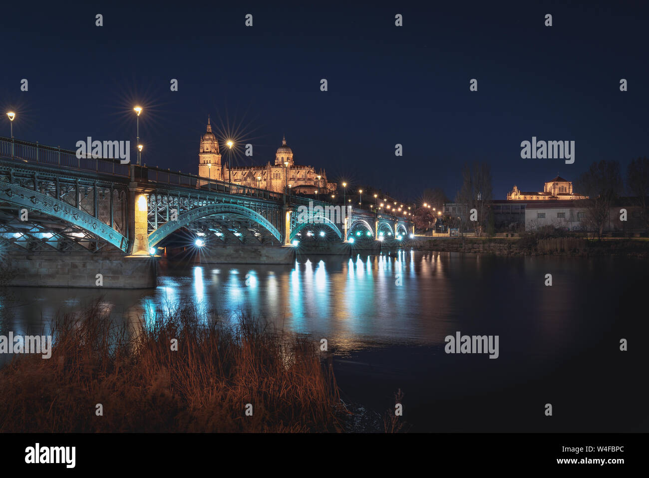 La Cathédrale de Salamanque avec vue sur l'horizon et Enrique Estevan pont à partir de la rivière Tormes la nuit - Salamanque, Castille et Leon, Espagne Banque D'Images