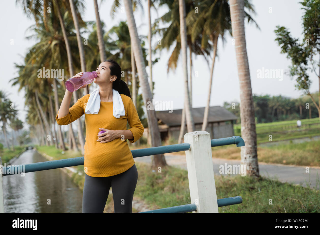 Femme enceinte après entraînement une bouteille d'eau potable Banque D'Images