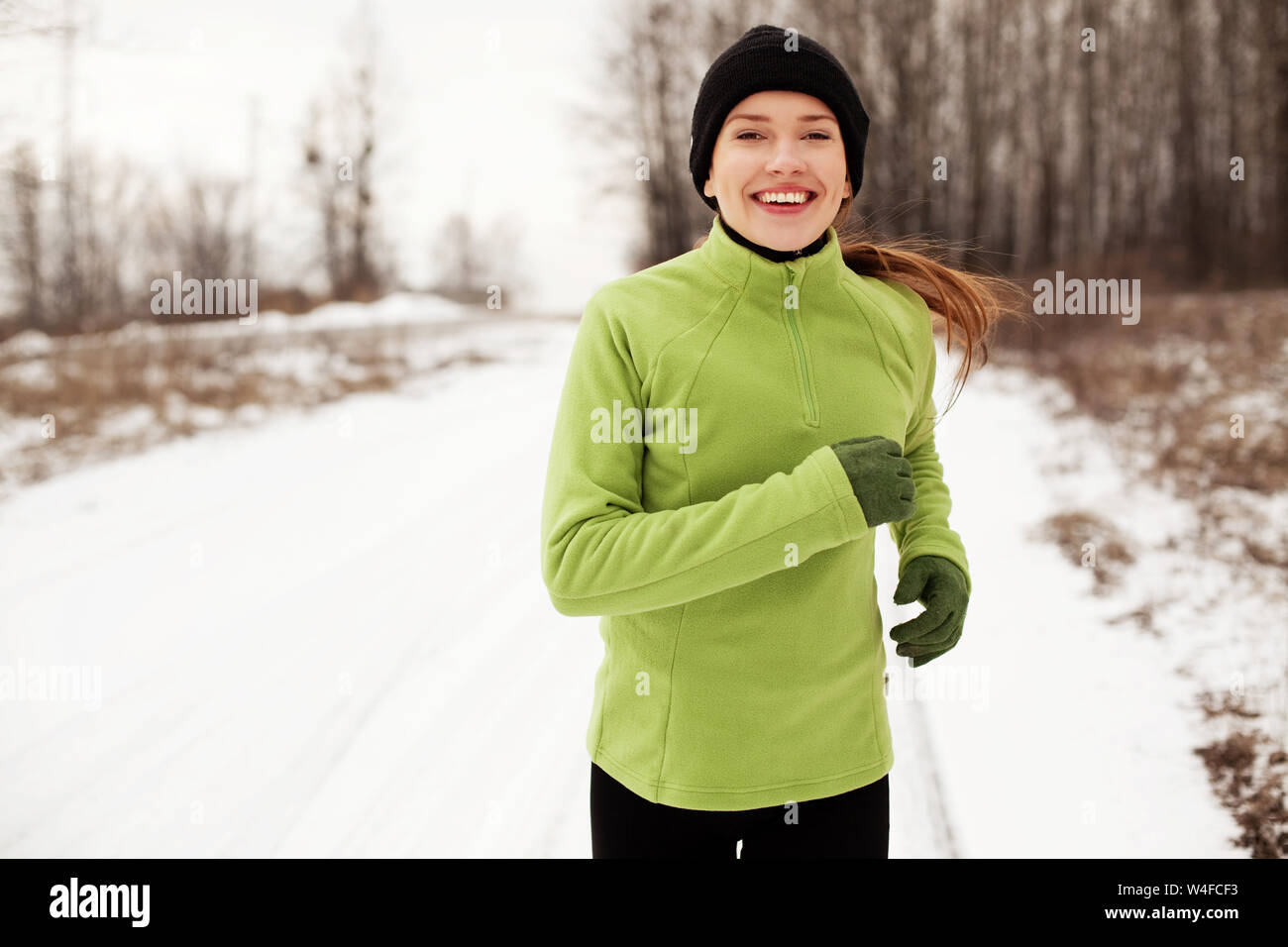 Cheerful woman jogging le matin d'hiver froid Banque D'Images