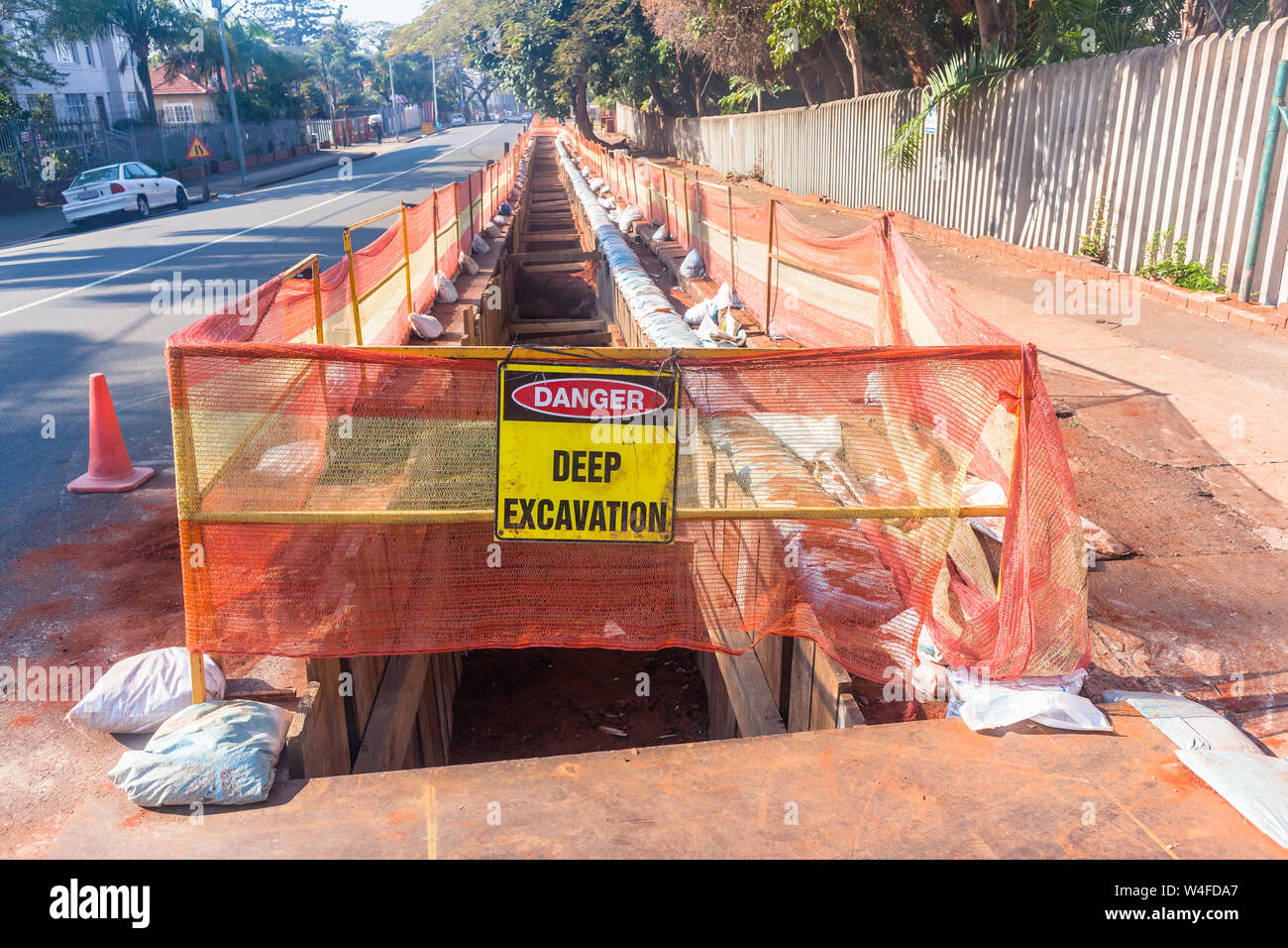 La construction de routes Terrassement tranchée profonde avec un chiffon de protection et de sacs pour les nouveaux câbles d'alimentation d'électricité zone résident d'installation Banque D'Images