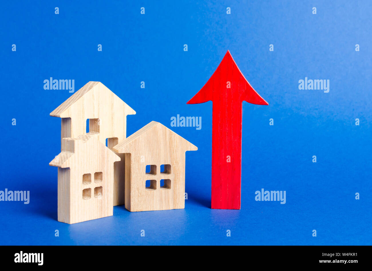 Trois maisons en bois rouge et flèche vers le haut. Augmenter la valeur de l'immobilier. Des taux élevés de construction, forte liquidité. L'offre et de la demande. Les prix du logement, b Banque D'Images