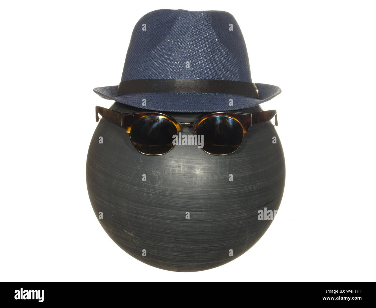 Men's chapeau bleu foncé et noir lunettes sur une balle en plastique isolé sur fond blanc. Banque D'Images