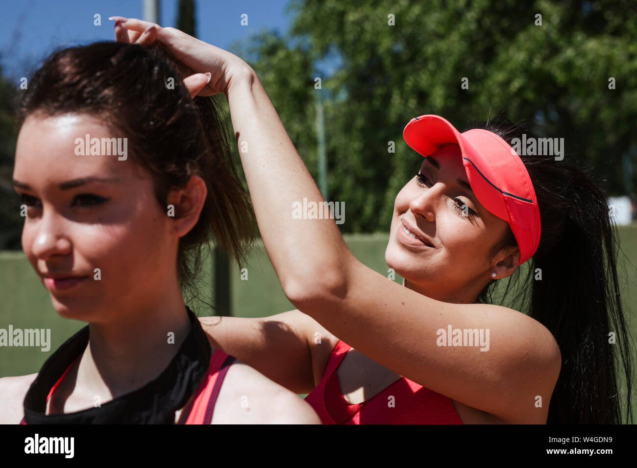 Female tennis player faisant les cheveux de son partenaire formation. Banque D'Images