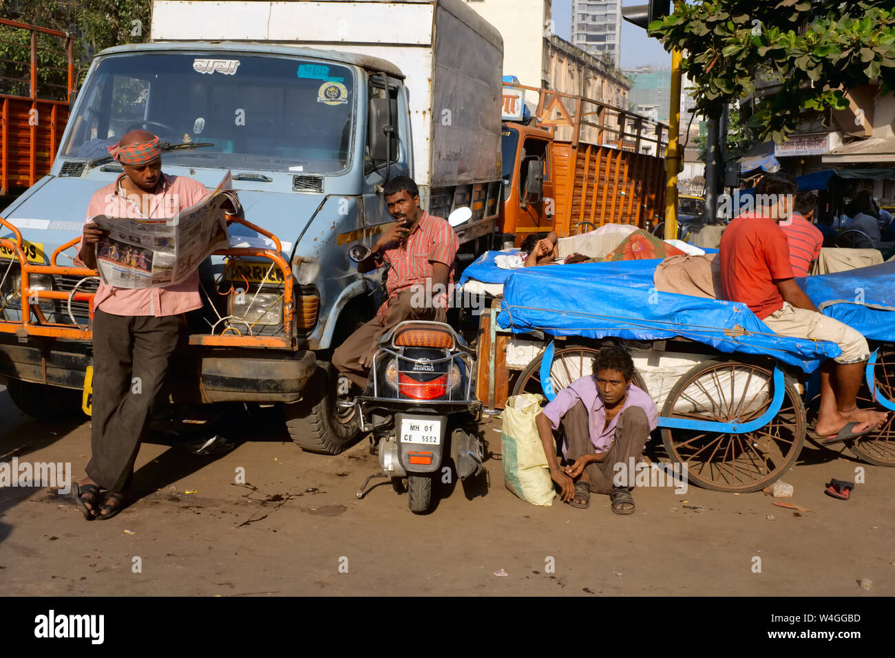 Les chauffeurs de camions et leurs auxiliaires, prendre du repos dans un quartier pauvre à Mumbai, Inde Banque D'Images