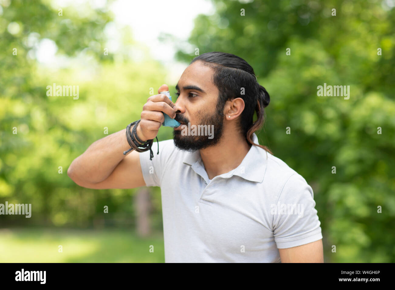 Jeune homme dans la nature en utilisant l'asthme inhalateur Banque D'Images