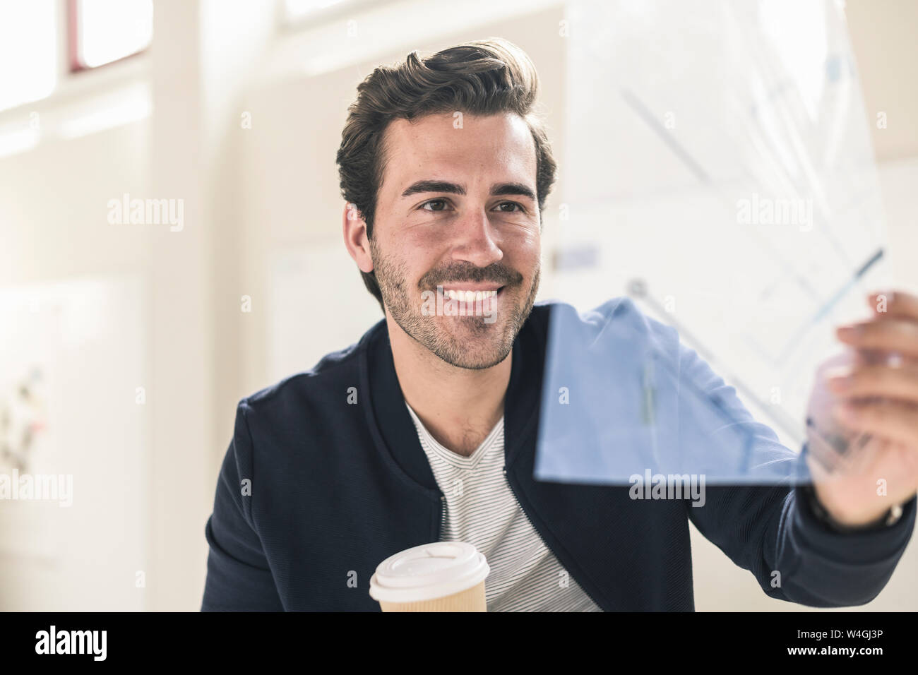 Young businessman in office holding d'aluminium d'un plan directeur Banque D'Images