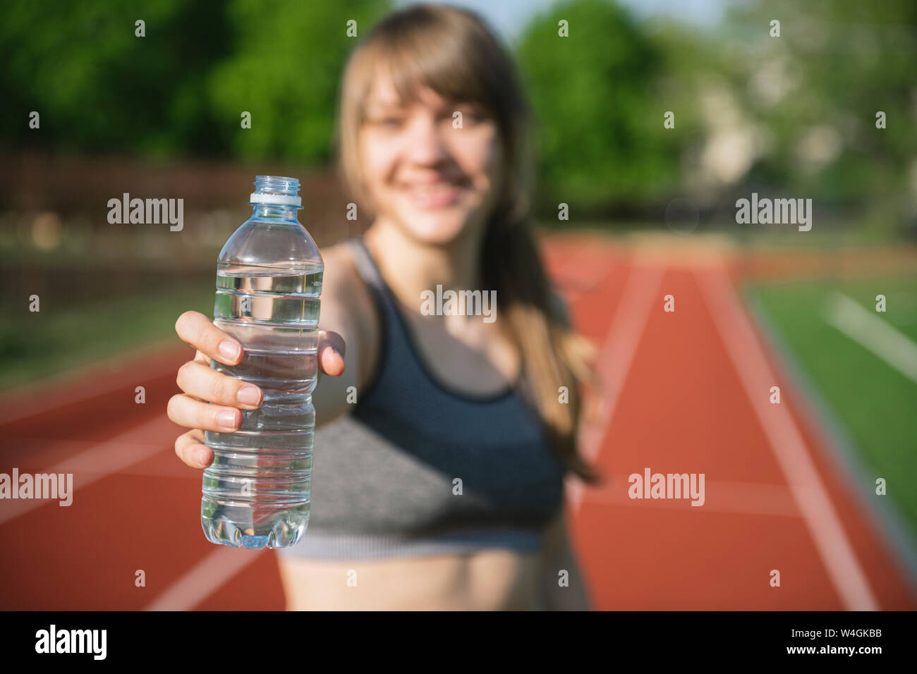 Grande sportive offrant une bouteille d'eau Banque D'Images