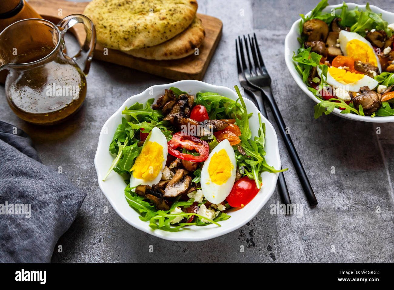 Salade de roquette avec poêlée de champignons, oeuf dur, tomates et feta Banque D'Images