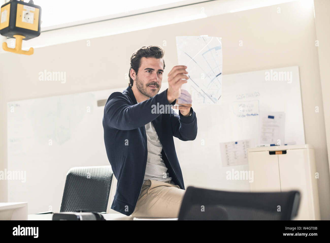 Young businessman in office holding d'aluminium d'un plan directeur Banque D'Images