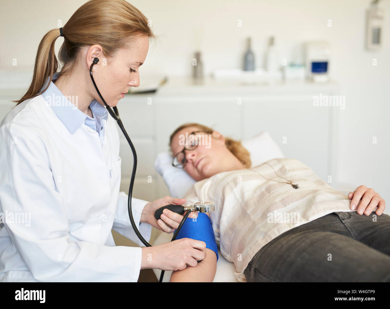 Femme médecin de prendre la tension artérielle du patient dans la pratique médicale Banque D'Images