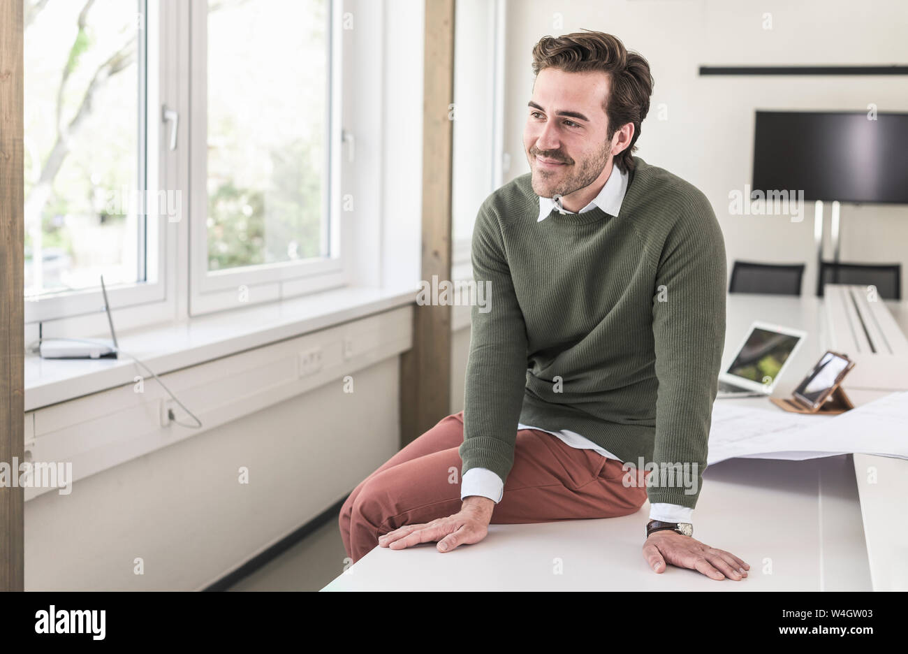 Succès, young businessman sitting in boardroom Banque D'Images