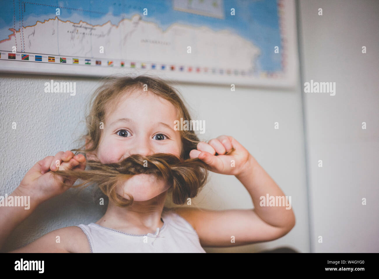 Portrait d'une jeune fille jouant avec ses longs cheveux moustache avec ses tresses Banque D'Images Portrait d'une jeune fille jouant avec ses longs cheveux moustache avec ses tresses Banque D'Images