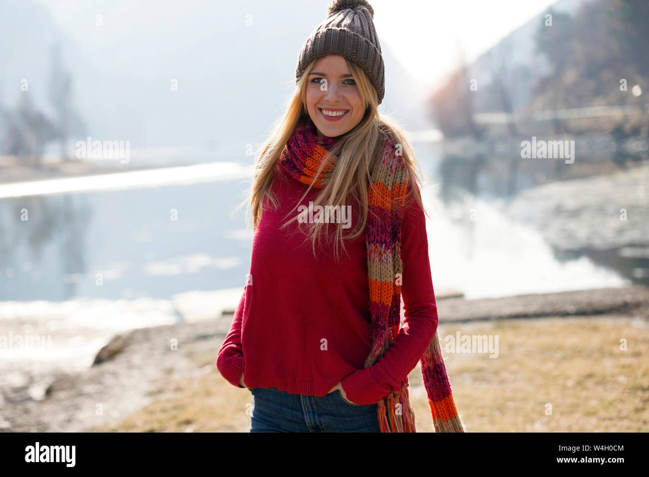 Jeune femme blonde au bord d'un lac en hiver Banque D'Images